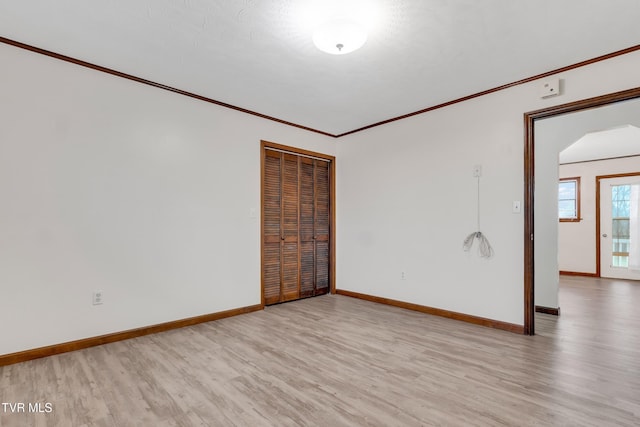 unfurnished room with light hardwood / wood-style flooring and crown molding