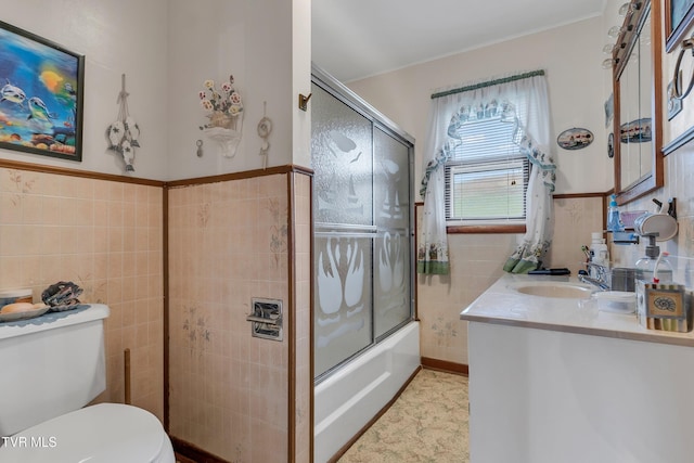 full bathroom with vanity, toilet, shower / bath combination with glass door, and tile walls