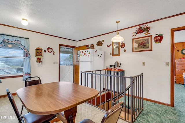 carpeted dining area featuring crown molding