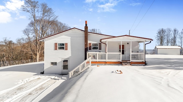 view of front of property featuring a chimney and a porch