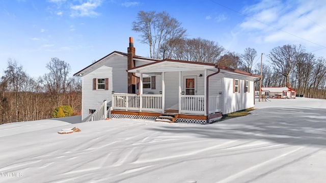 view of front of house featuring covered porch and a chimney