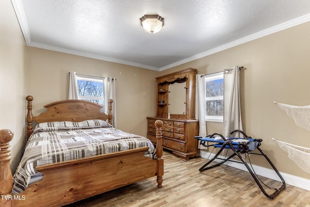 bedroom featuring light wood finished floors, a textured ceiling, baseboards, and crown molding