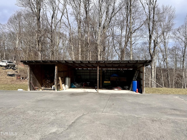 garage with concrete driveway and a carport