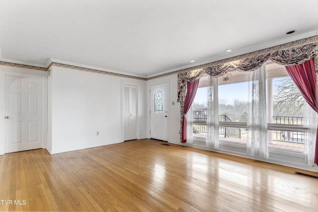 unfurnished living room with hardwood / wood-style flooring and ornamental molding