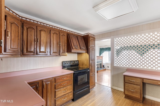 kitchen with premium range hood, black range with electric stovetop, light hardwood / wood-style flooring, and crown molding