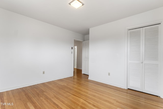 unfurnished bedroom featuring light hardwood / wood-style flooring and a closet