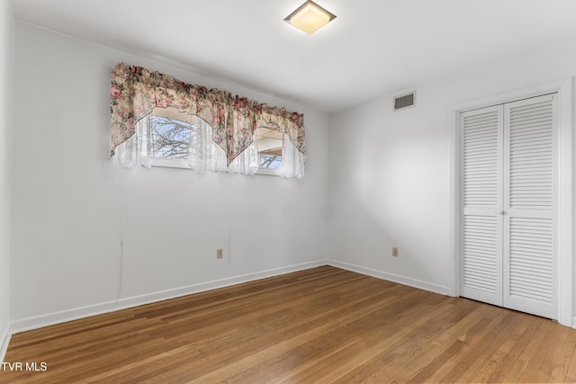 unfurnished bedroom featuring hardwood / wood-style floors and a closet