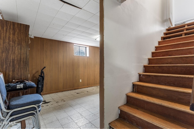 staircase featuring wooden walls