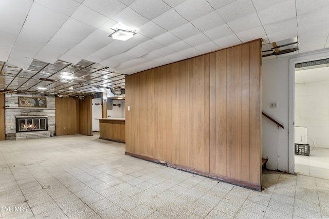 basement with a fireplace and wooden walls