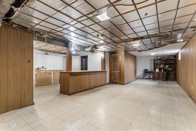 basement featuring wooden walls