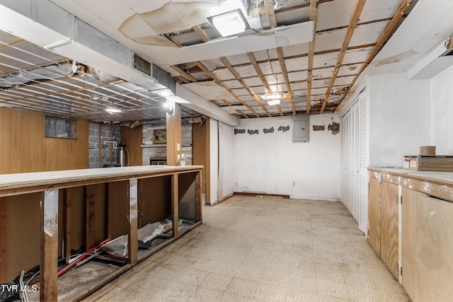 basement with wooden walls and electric panel