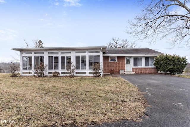 view of front of property featuring a sunroom and a front yard