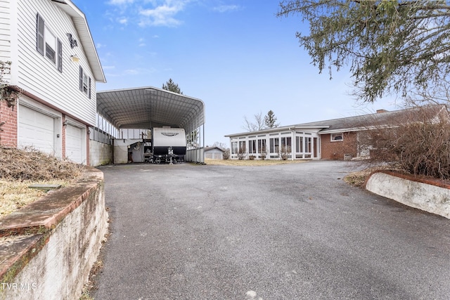 exterior space with a carport, a garage, and a sunroom