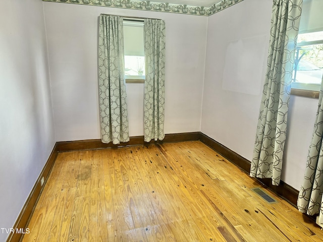 unfurnished room featuring light hardwood / wood-style floors and plenty of natural light