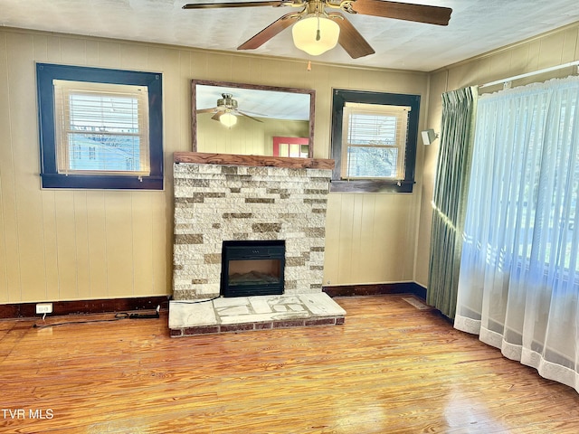 living room featuring wood walls, wood-type flooring, and a fireplace