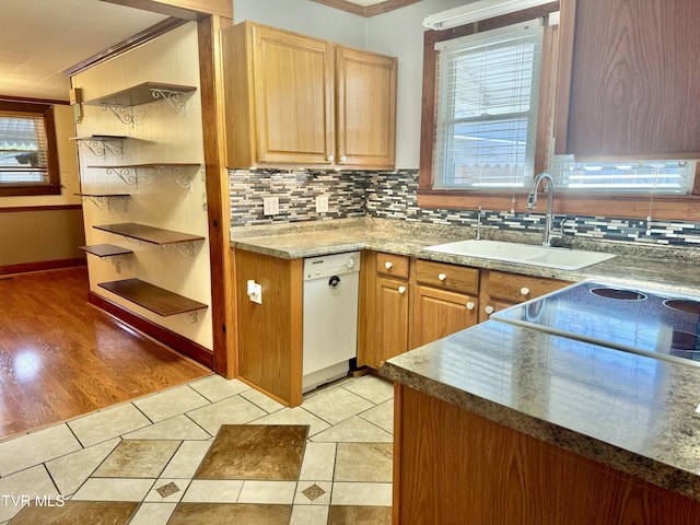 kitchen featuring dishwasher, light tile patterned flooring, crown molding, and sink