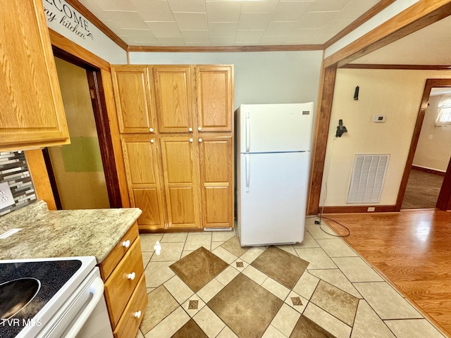 kitchen with light wood-type flooring, white appliances, light stone countertops, and ornamental molding