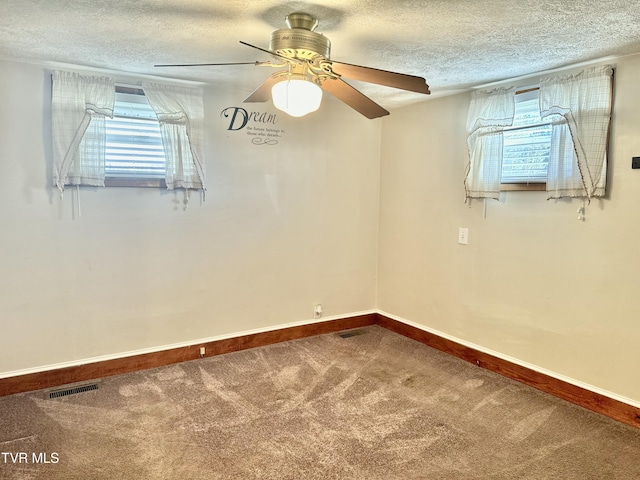 carpeted spare room featuring ceiling fan and a textured ceiling