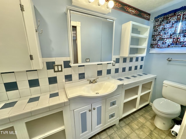 bathroom featuring vanity, toilet, and backsplash