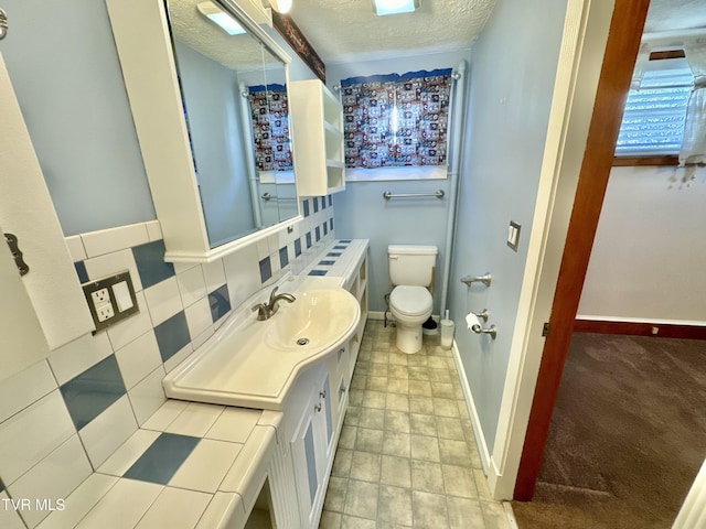 bathroom featuring decorative backsplash, toilet, a textured ceiling, and vanity