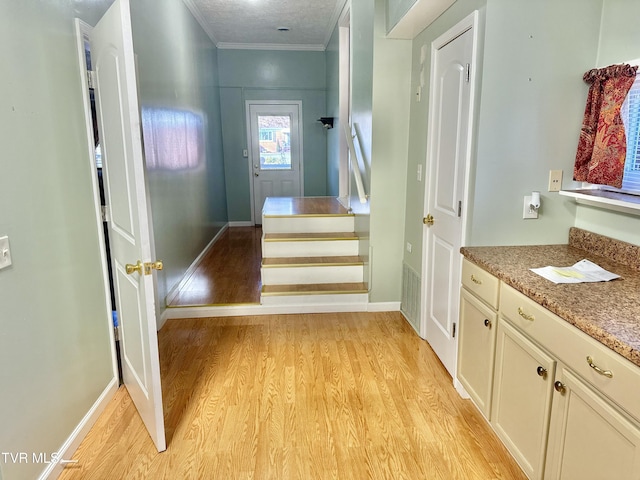 stairs featuring hardwood / wood-style floors, a textured ceiling, and crown molding