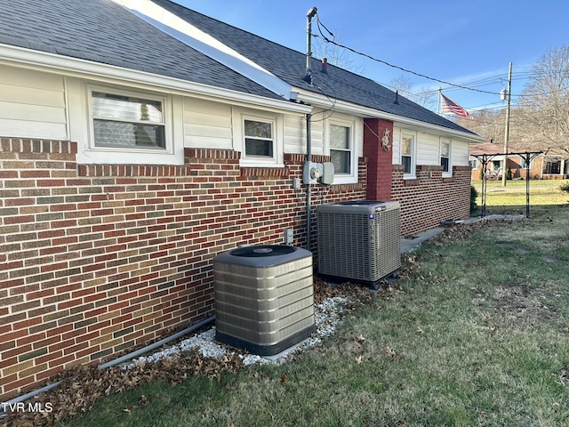 exterior space featuring central AC and a lawn