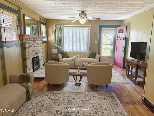 living room featuring a wealth of natural light, a fireplace, ceiling fan, and hardwood / wood-style floors