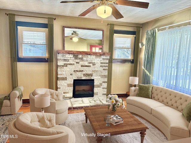 living room featuring a fireplace, light wood-type flooring, and wooden walls