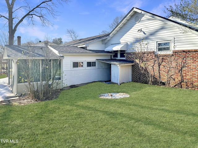 exterior space featuring a sunroom and a lawn