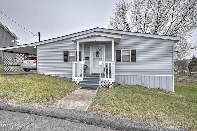 manufactured / mobile home featuring a front yard and a carport