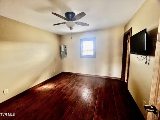 empty room with wood-type flooring, electric panel, and ceiling fan