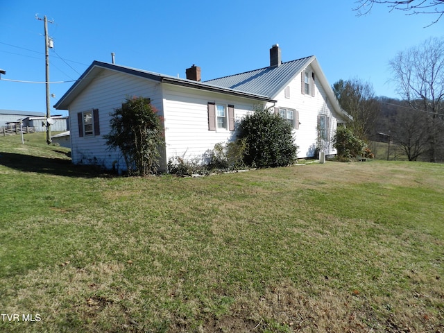 view of side of home with a yard