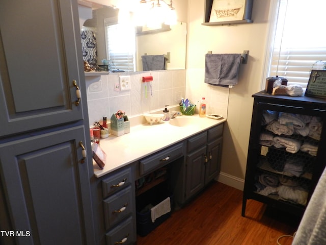 bathroom with hardwood / wood-style floors, vanity, and tasteful backsplash