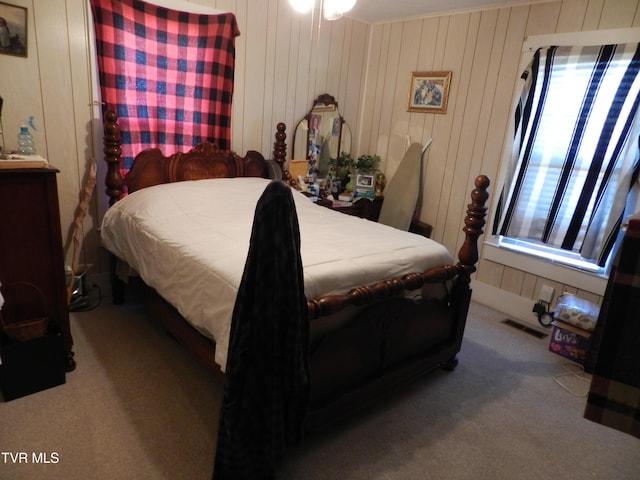 bedroom featuring carpet floors and wood walls