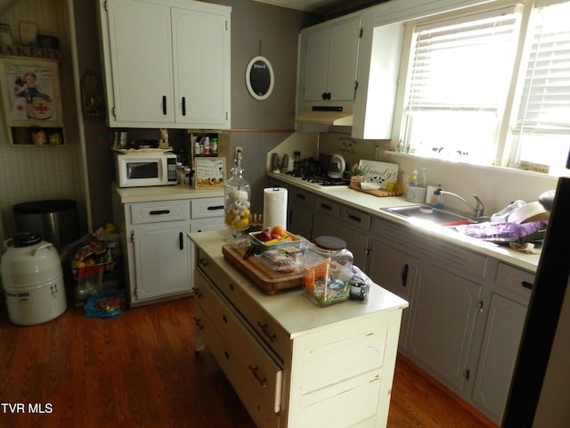 kitchen with white cabinets, dark hardwood / wood-style flooring, sink, and gas cooktop