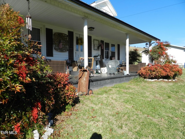 back of property featuring a porch and a lawn