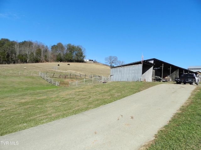 view of yard featuring a rural view and an outbuilding