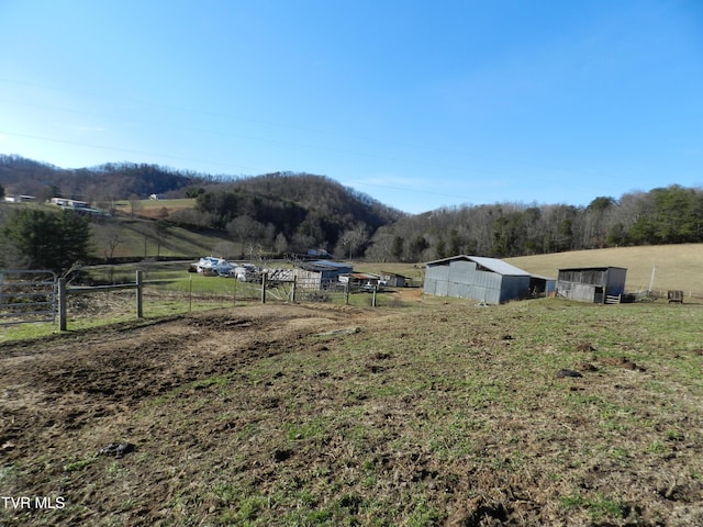 view of yard featuring a rural view and an outdoor structure