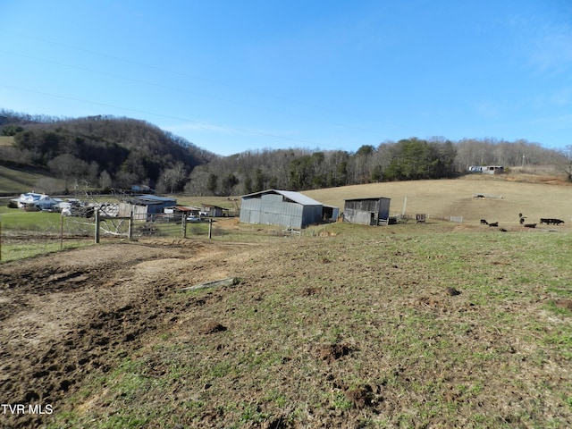 view of yard with a rural view and an outdoor structure