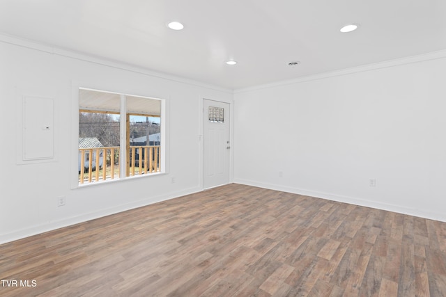 empty room featuring wood-type flooring and ornamental molding