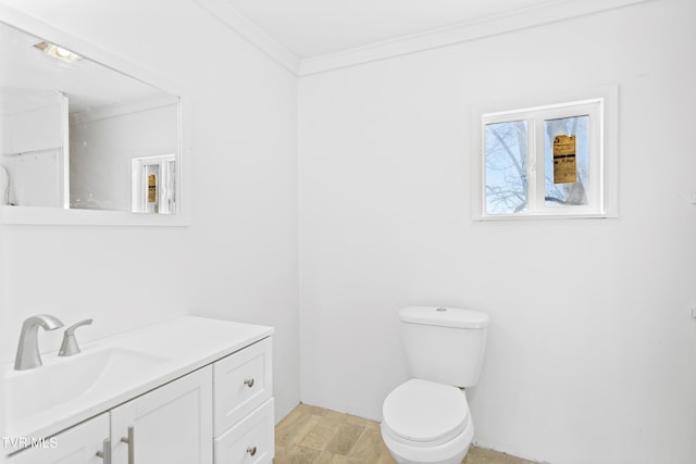 bathroom with vanity, toilet, and crown molding