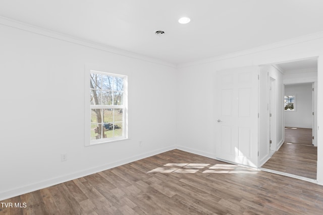 spare room with hardwood / wood-style flooring, plenty of natural light, and crown molding