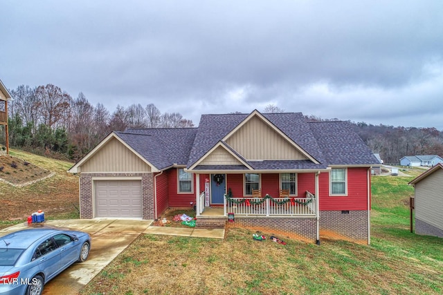 view of front of home featuring a porch, a garage, and a front yard