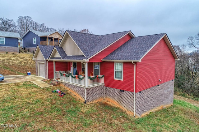 view of front of home featuring a front lawn, covered porch, and a garage