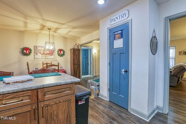 kitchen featuring dark hardwood / wood-style flooring and decorative light fixtures