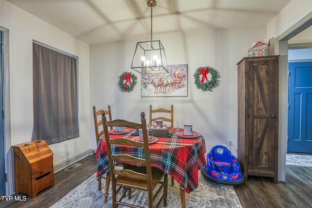 dining room with dark hardwood / wood-style floors and a chandelier