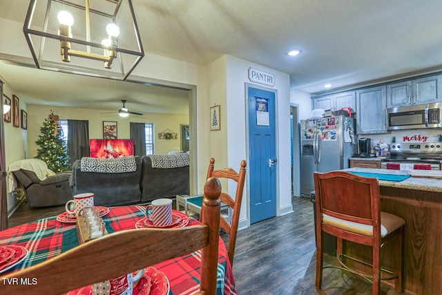 dining space with dark hardwood / wood-style floors and ceiling fan