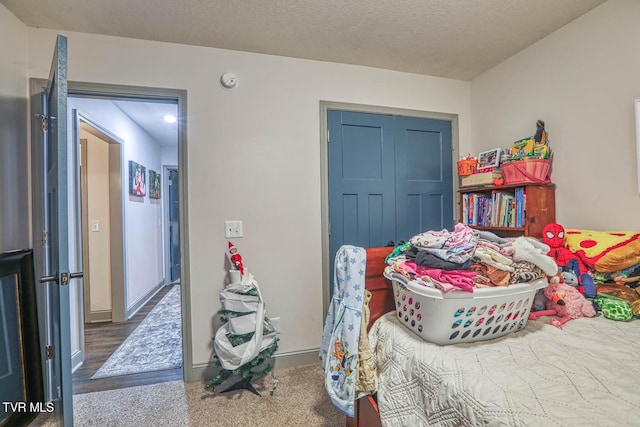 carpeted bedroom featuring a textured ceiling and a closet