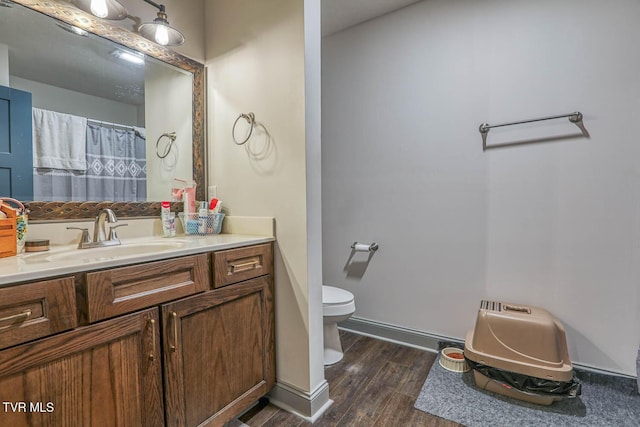 bathroom with hardwood / wood-style floors, vanity, and toilet