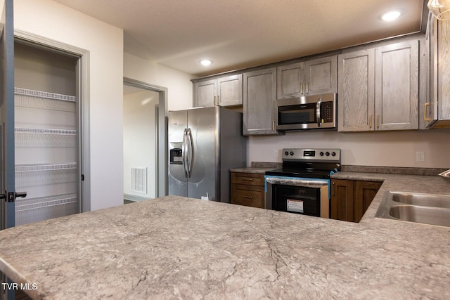 kitchen with sink, kitchen peninsula, and stainless steel appliances